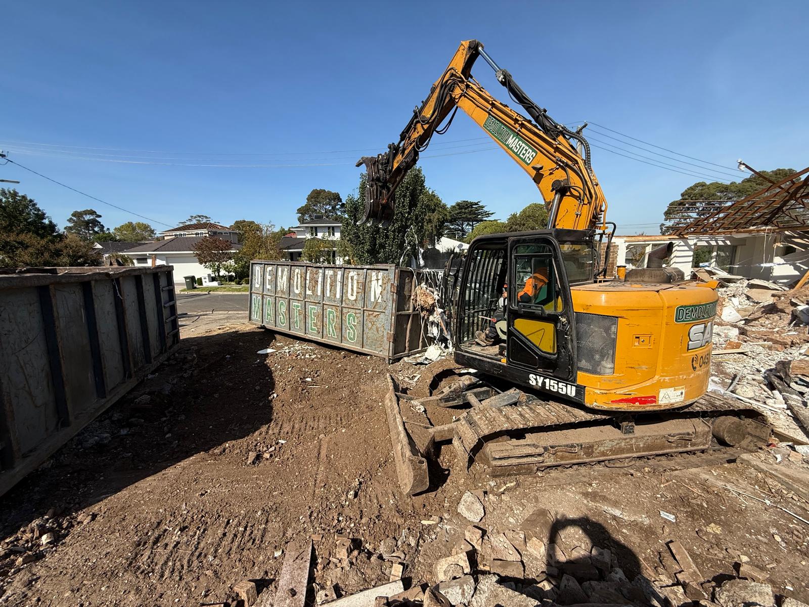 Large Demolition Masters branded bin positioned on a Melbourne demolition site alongside an excavator